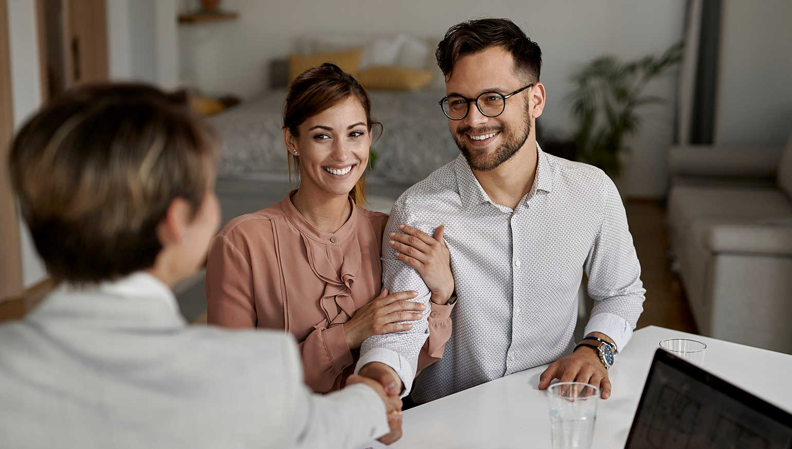 Couple meeting with and shaking hands with a contractor