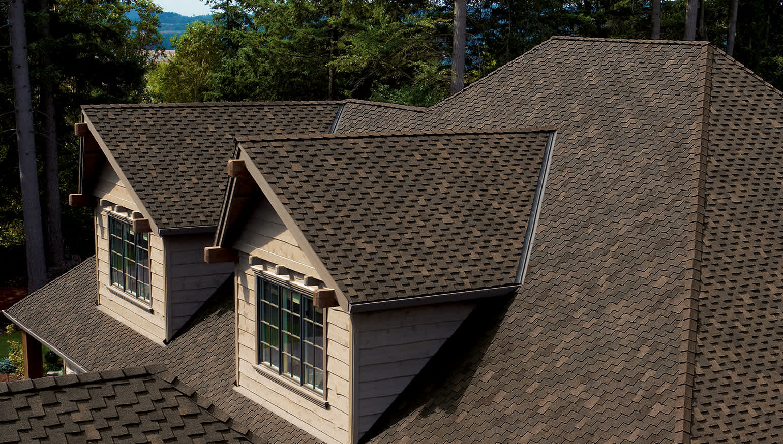Image of a roof showing how Woodmoor® and Woodcrest® asphalt shingles have an installed shape of staggered wood shake