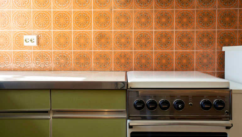 Vintage retro kitchen with orange pattern tiles, american retro kitchen home interior design 70's style close-up