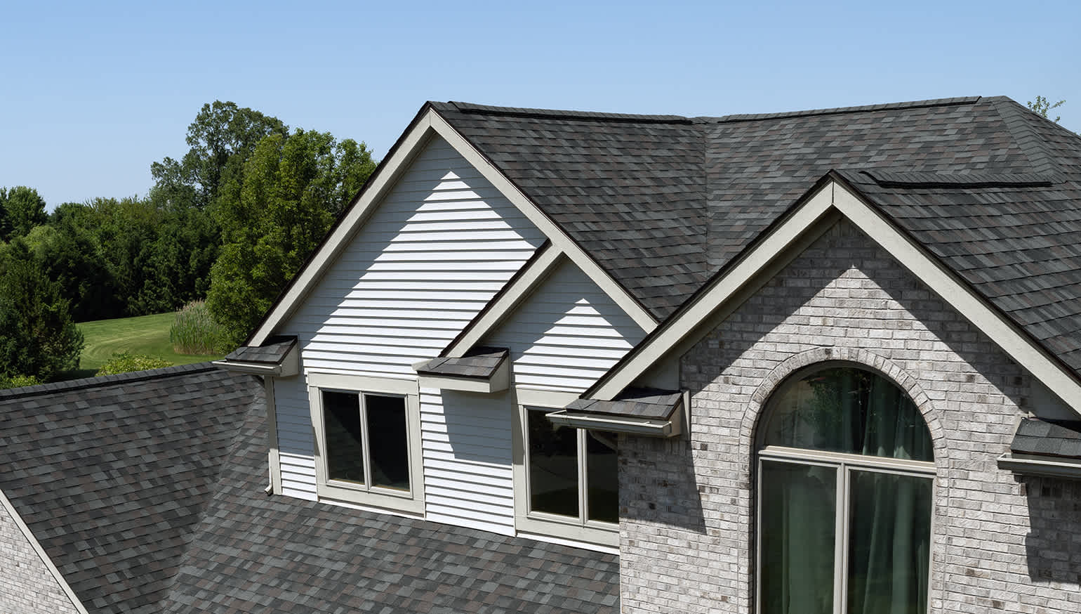 House with light grey brick and siding with Williamsburg Gray roofing shingles