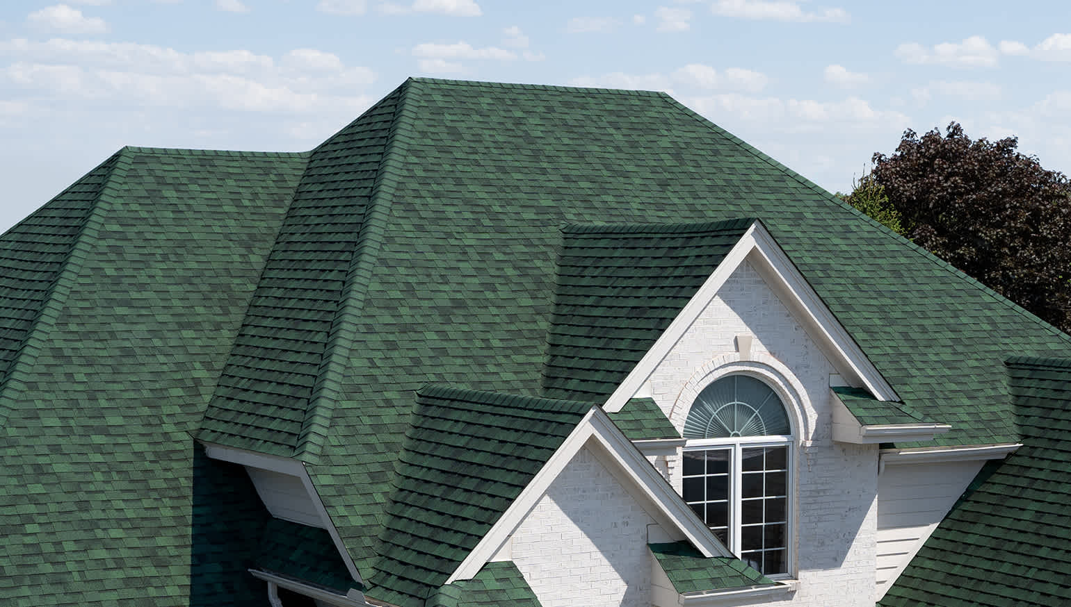 White brick home with Chateau Green asphalt roofing shingles