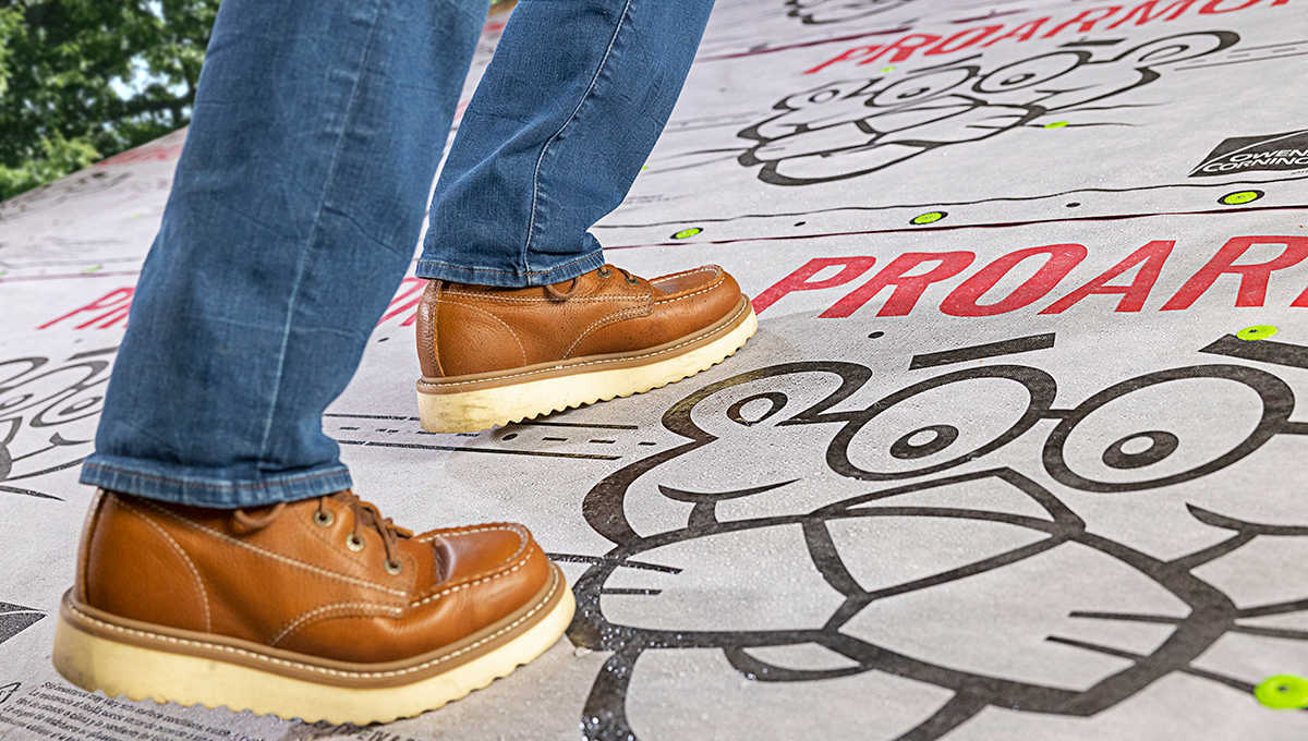 Contractor's feet show walking up a roof deck with Owens Corning ProArmor Underlayment installed