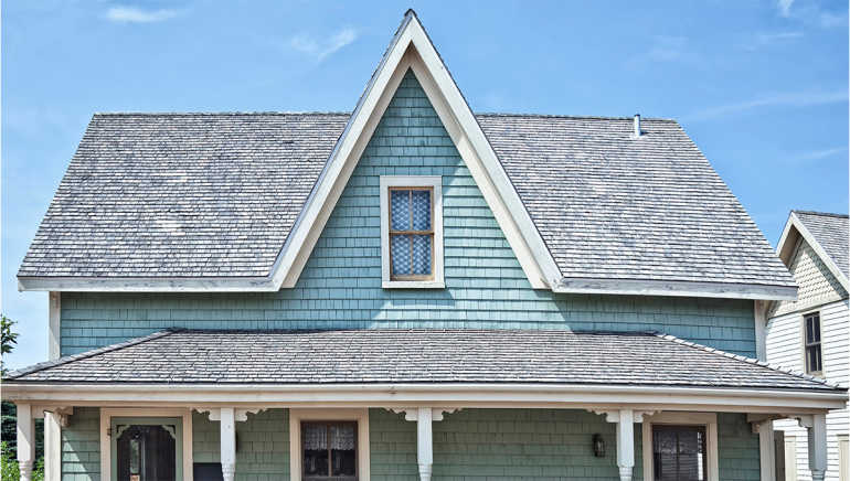 Residential shingle roof with visibly age worn shingles.