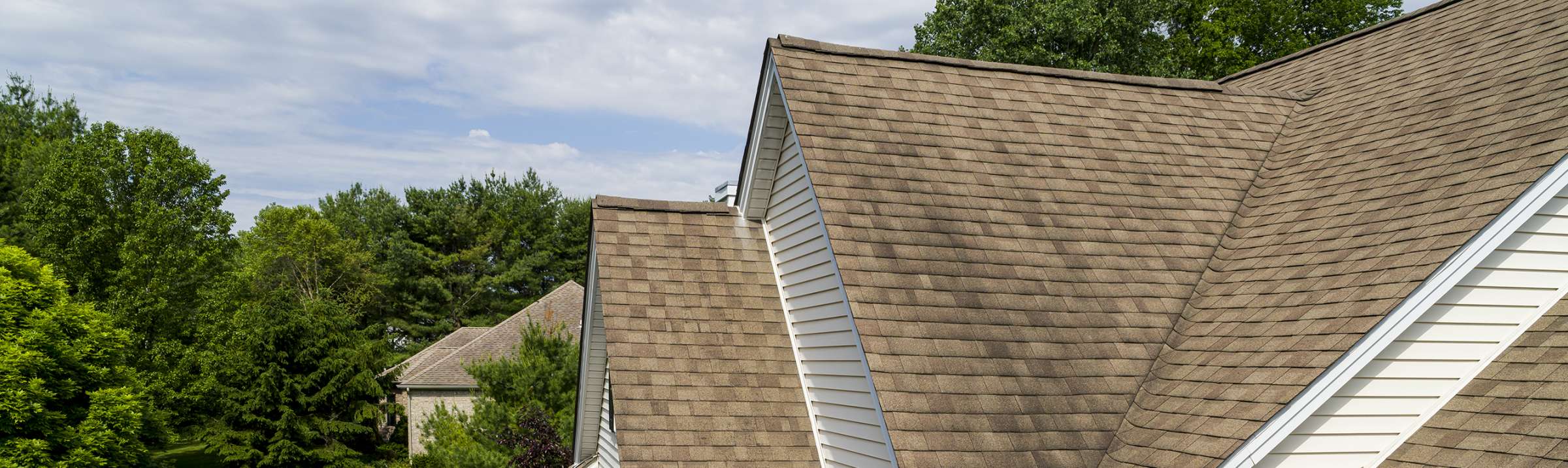 Medium tan rooftop with dark coloration on the shingles. 