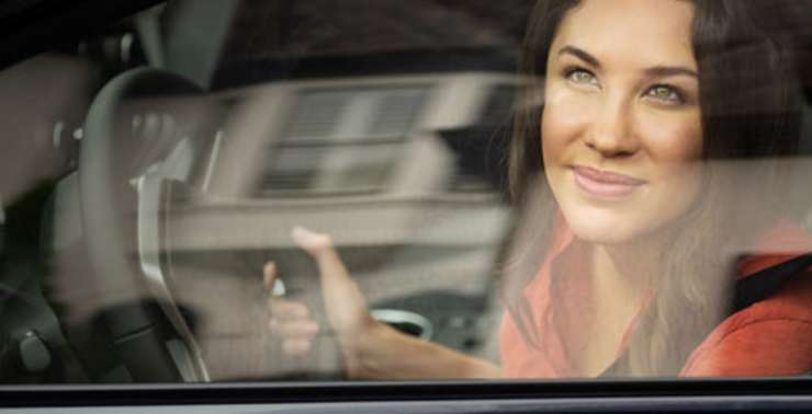 Photo of a woman looking out of her car window