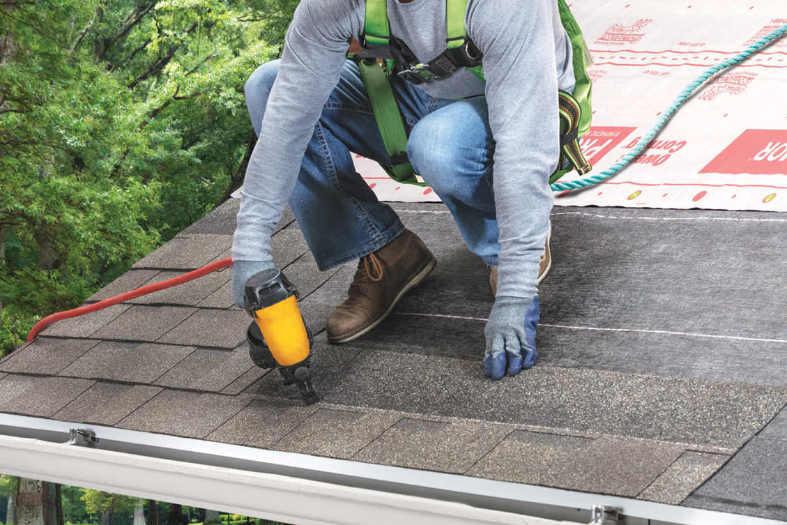 a contractor attaching shingles to a roof