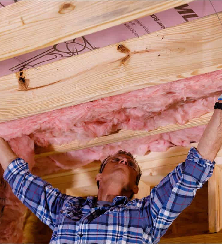 photo of man hanging insulation