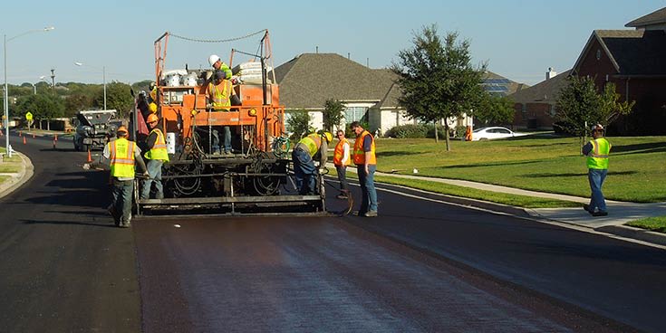 A construction crew laying asphalt