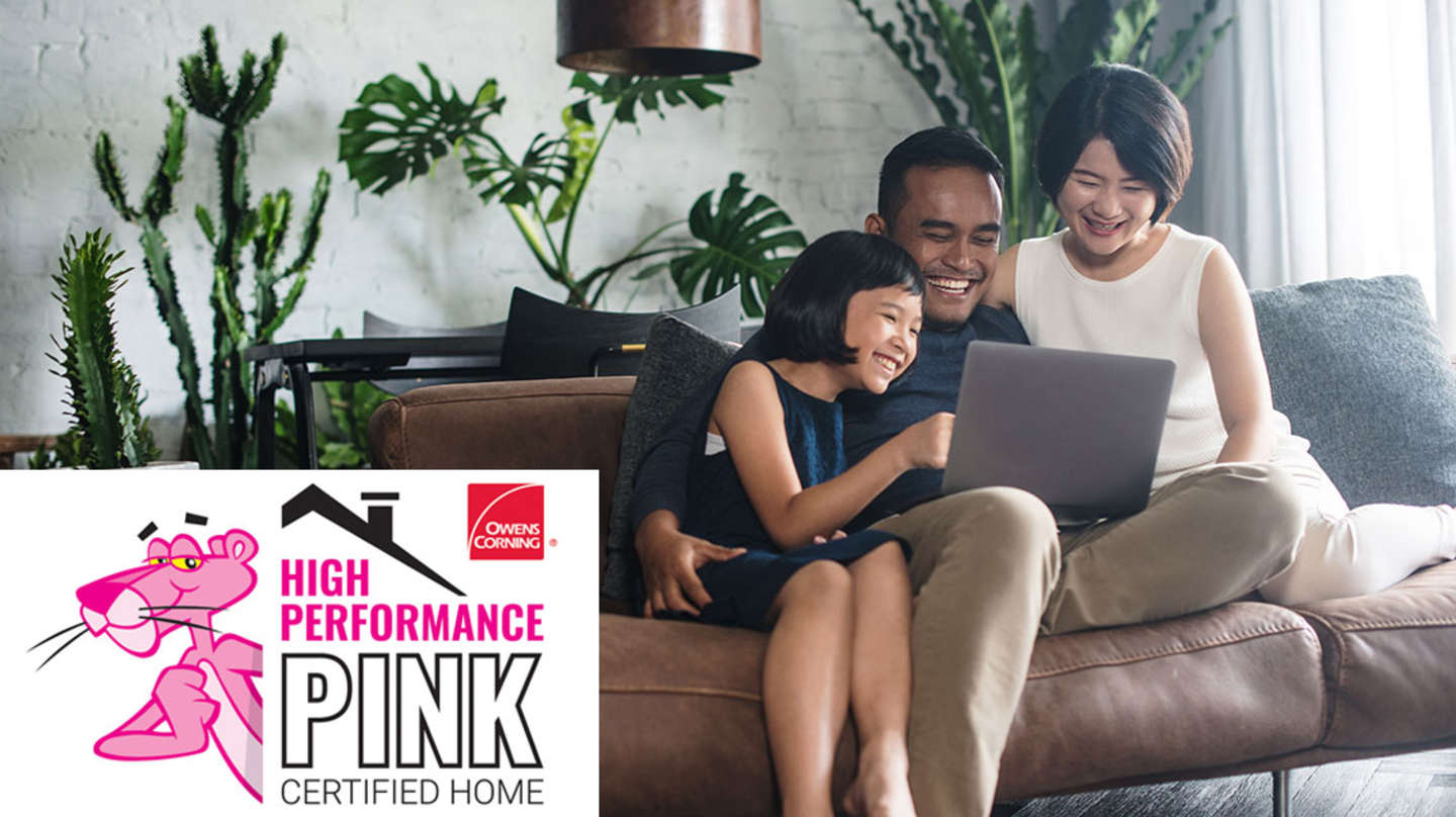 happy family sitting on a couch and looking at a laptop