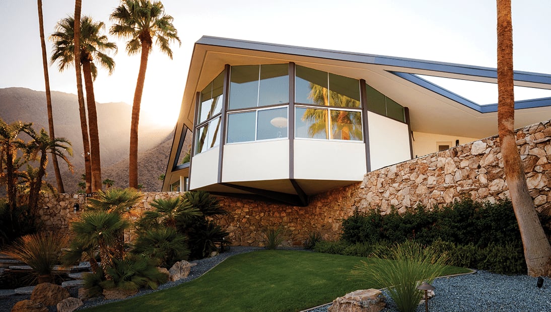 Photo of a house with windows and palm trees