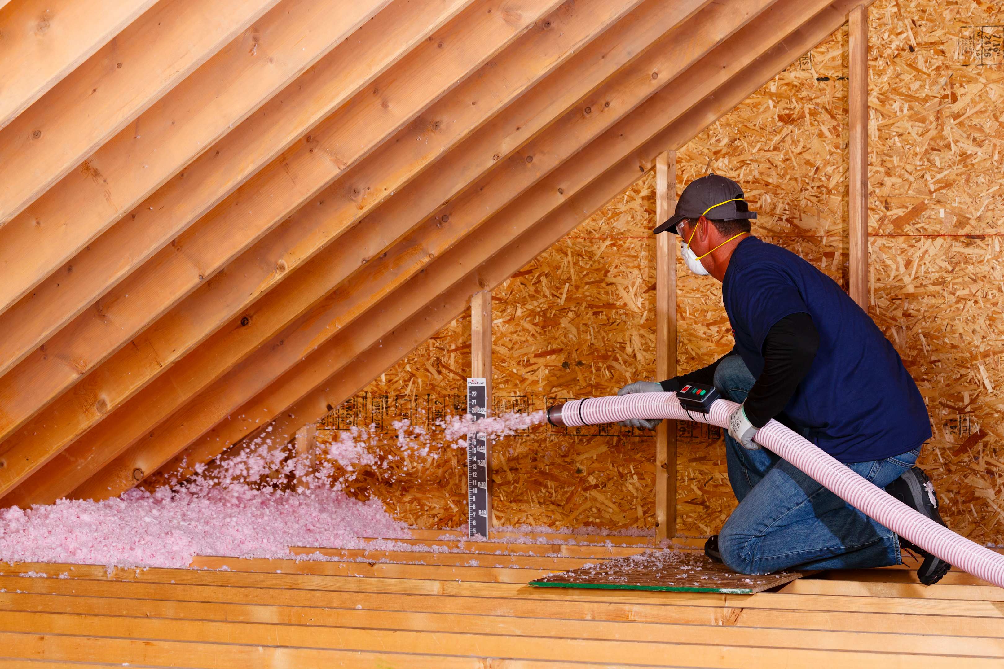 A contractor installing blown in attic insulation