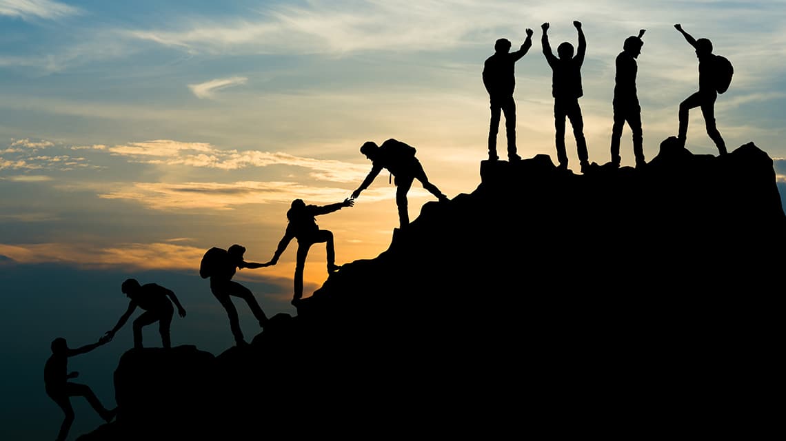 Photo of people climbing to the top of a mountain.
