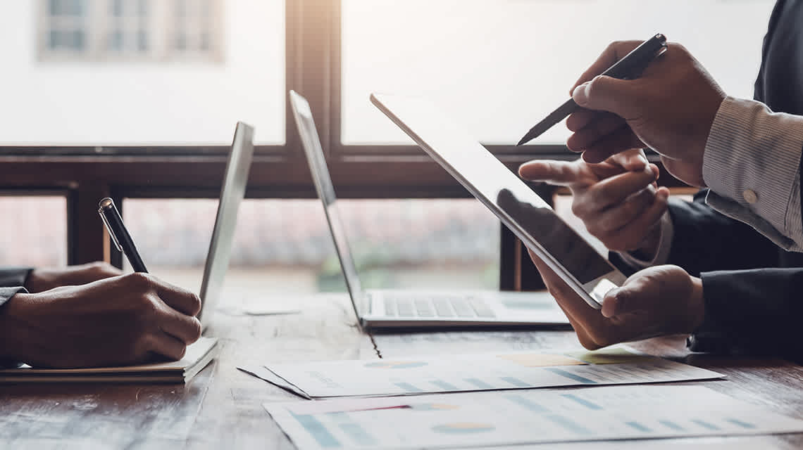 Photo of individuals collaborating on computers.