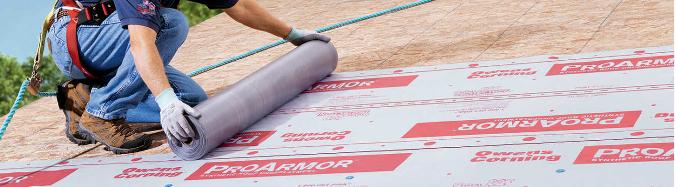 Photo of a contractor on top of a roof installing ProArmor underlayment