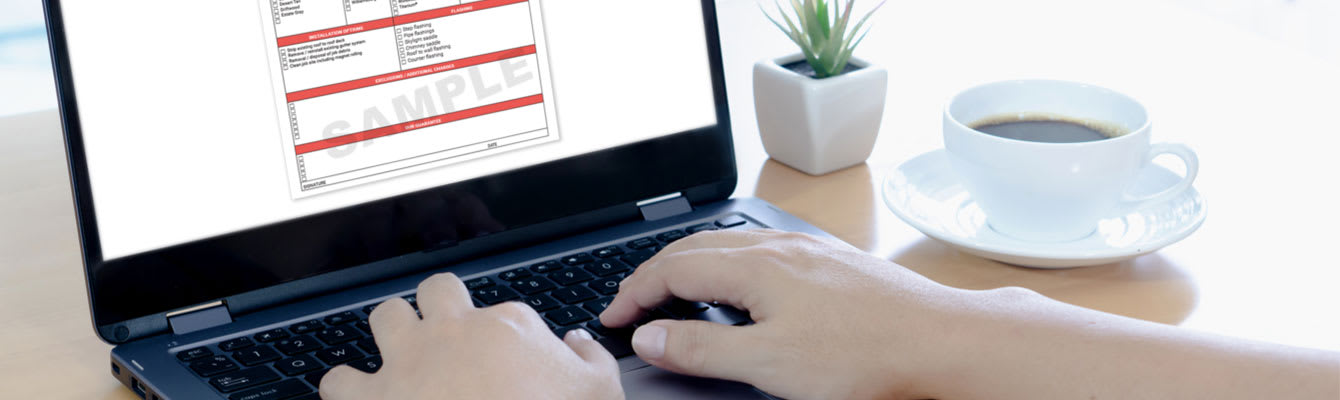 Closeup photo of hands typing on a laptop with a sample roof quote on the screen