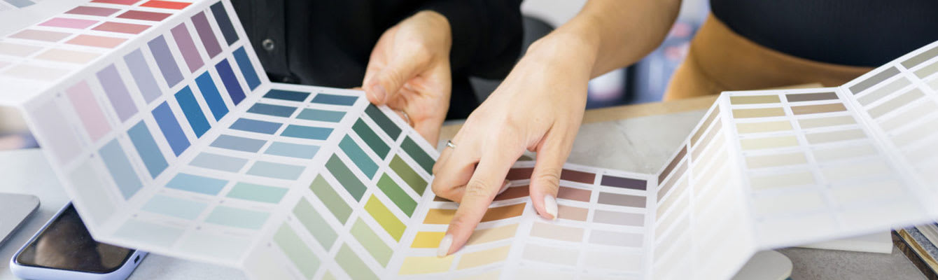 Photo of two people looking through a color swatch booklet