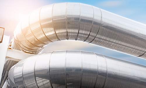 Sun shining on metal jacketed pipes