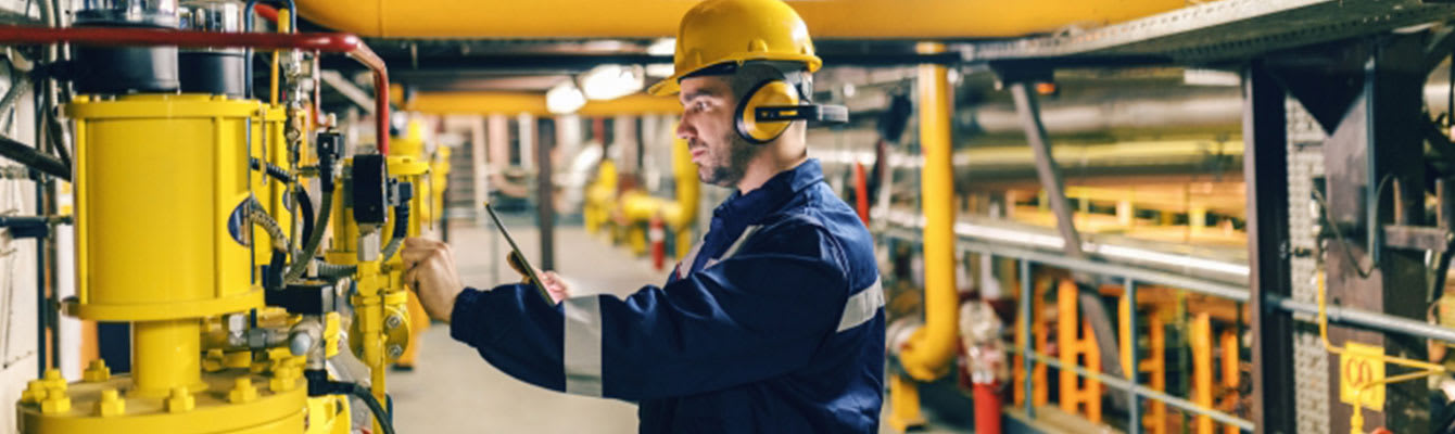 person in a plant working with loud equipment