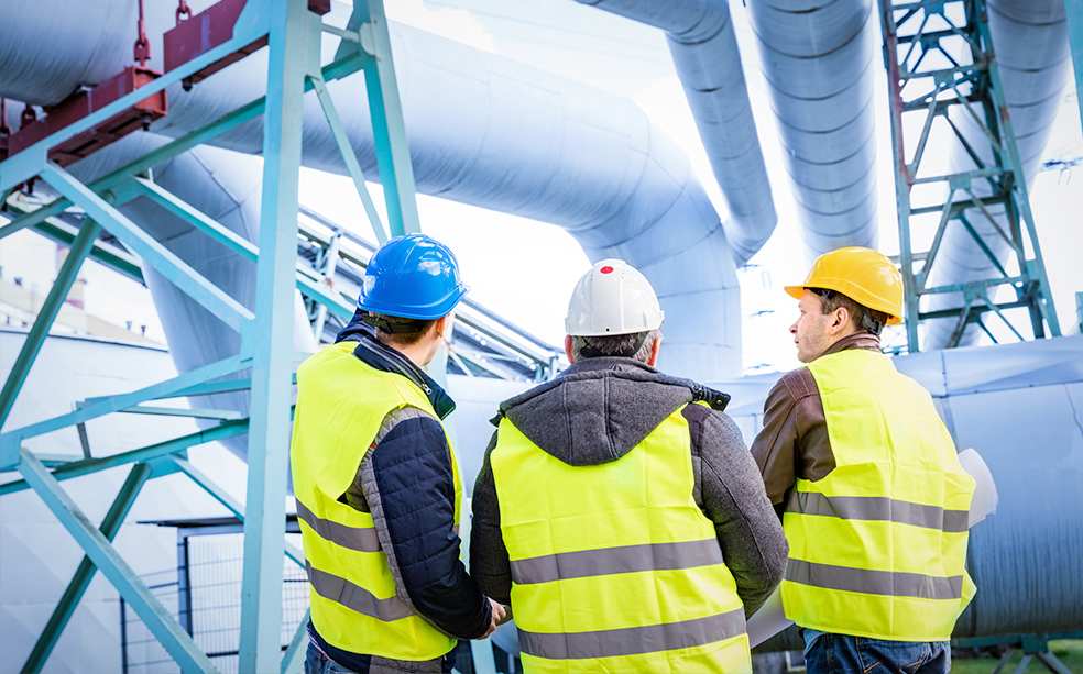 Men in safety gear at a processing plant.