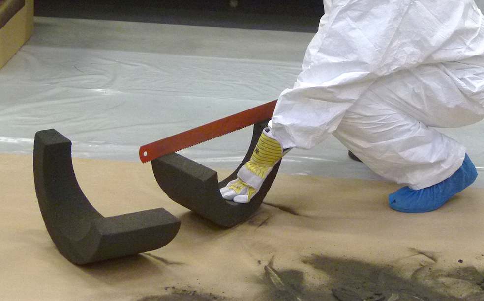 Factory worker measuring a prefabricated insulation component.
