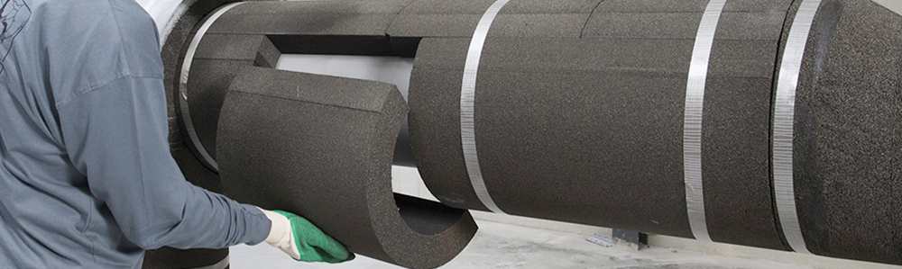 Prefabricated Foamglas insulation piece being installed on a pipe.