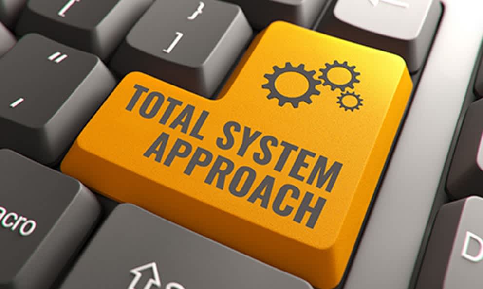 Photo of an orange computer key with the words "Total System Approach" on it