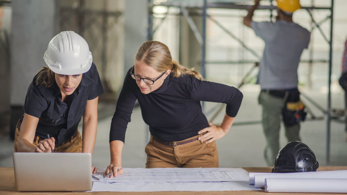 Photo of an architect reviewing plans with a contractor in a commercial building setting