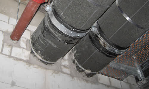 Large pipes with Foamglas insulation penetrating a wall
