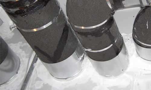 Large pipes with Foamglas insulation penetrating a wall