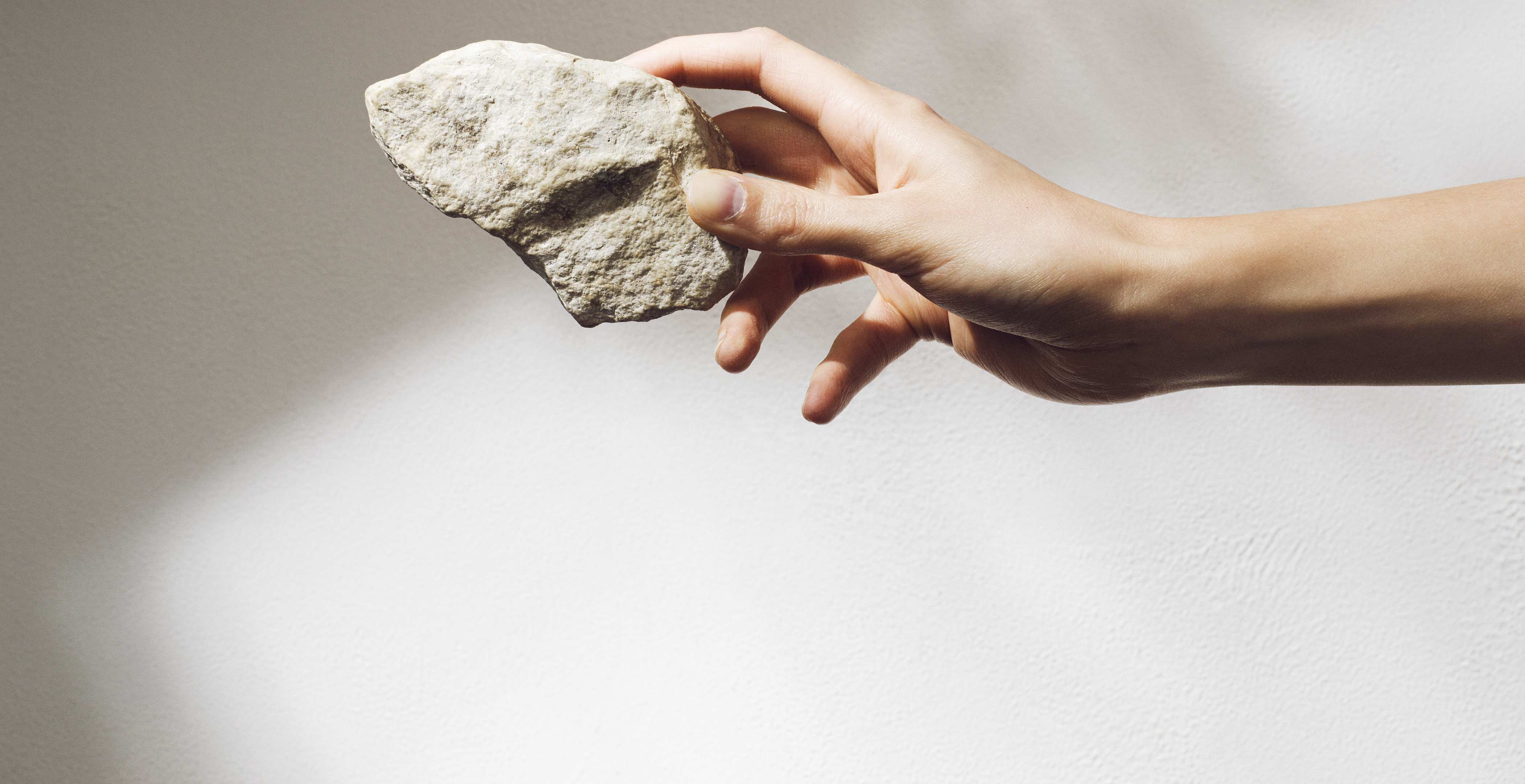 a hand holding a piece of stone
