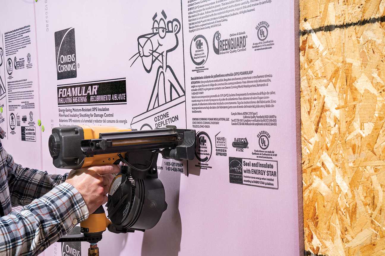 Man wearning plaid shirt installing foamular 150 foam board insulation 