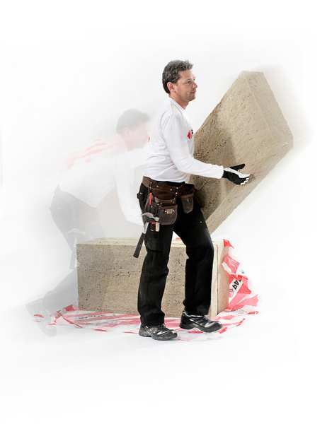 En mand i arbejdstøj holder en plade af PAROC Stenull