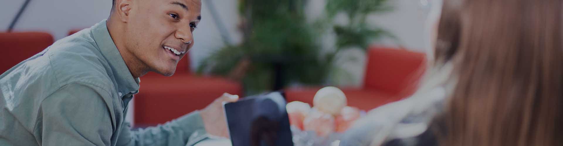 vyras ir moteris kalbasi biuro aplinkoje, priešakyje lašo formos piršto antspaudas