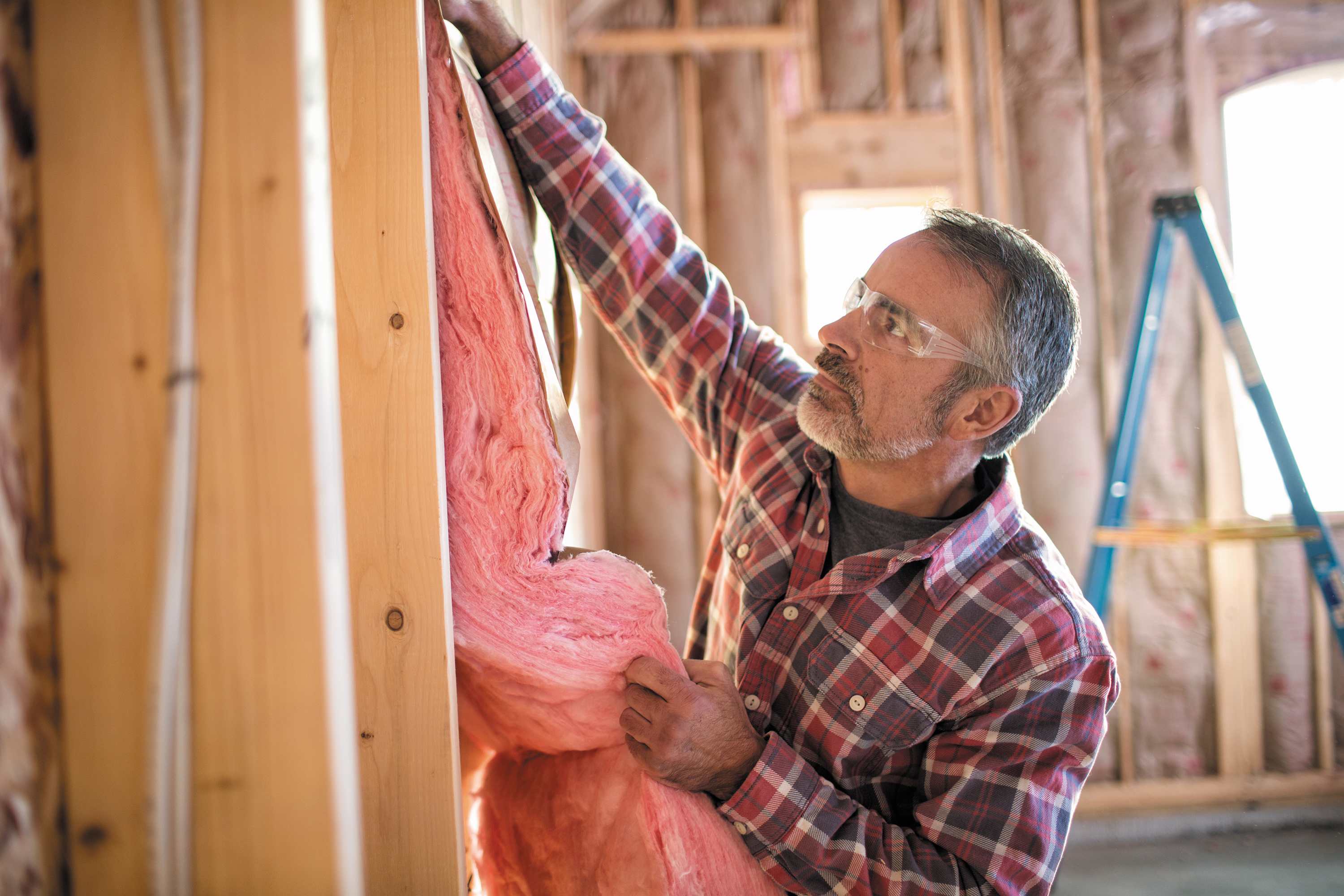 A contractor installing wall insulation