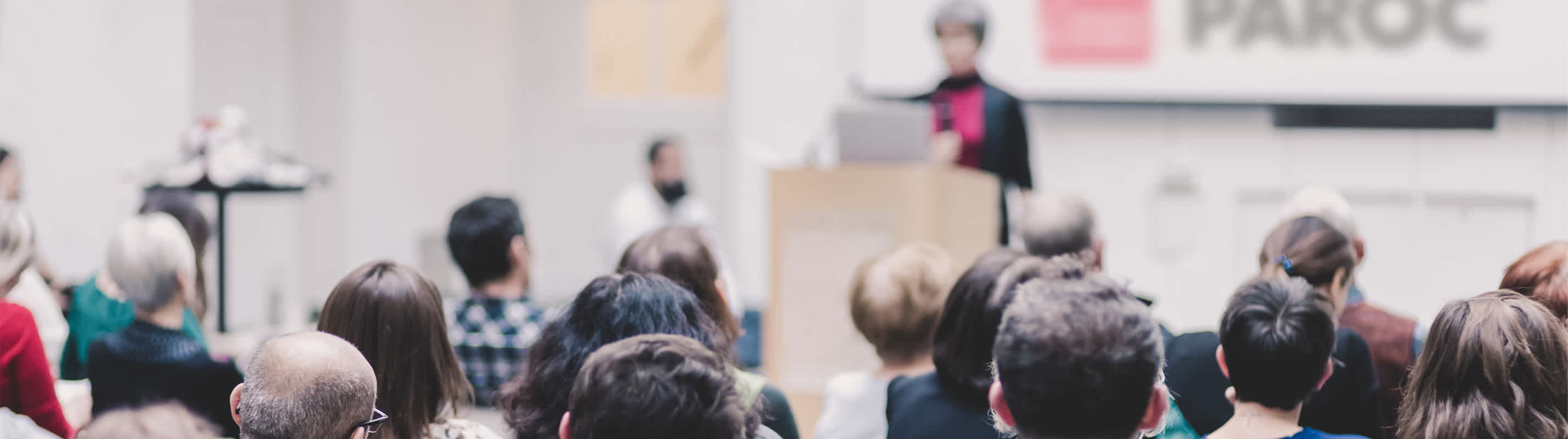 cilvēki klausās PAROC rīkotajā konferencē.