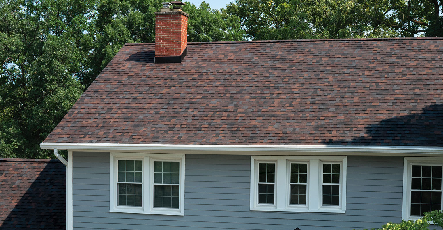 A blue house with a bourbon brown colored roof.