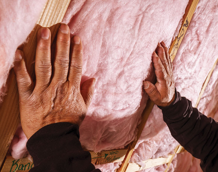 Closeup photo of hands installing insulation