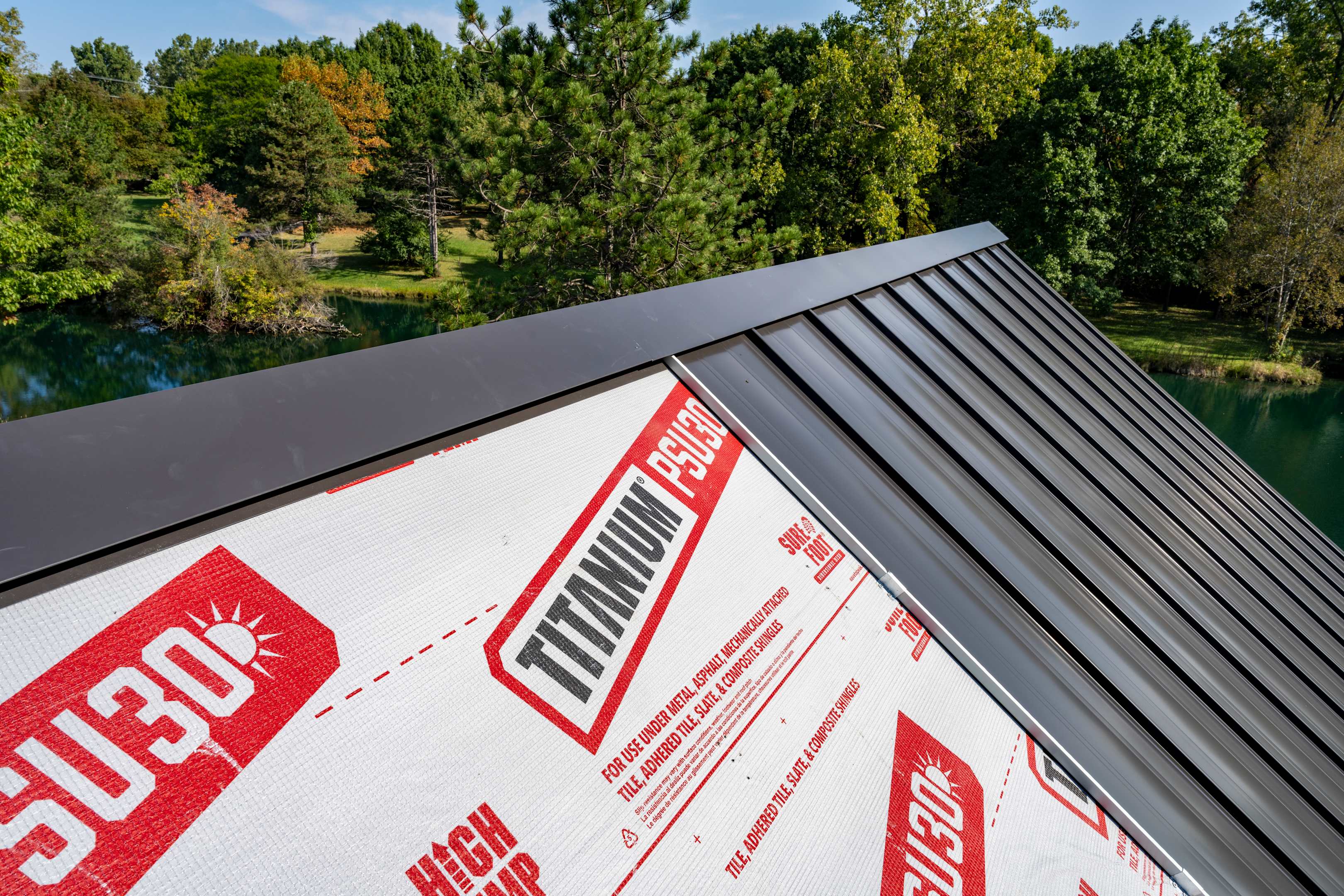 Contractor walking on three different metal roof underlayments on a roof deck