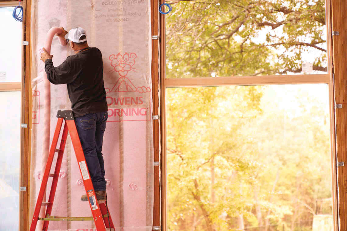 Photo of a contractor installing Owens Corning insulation