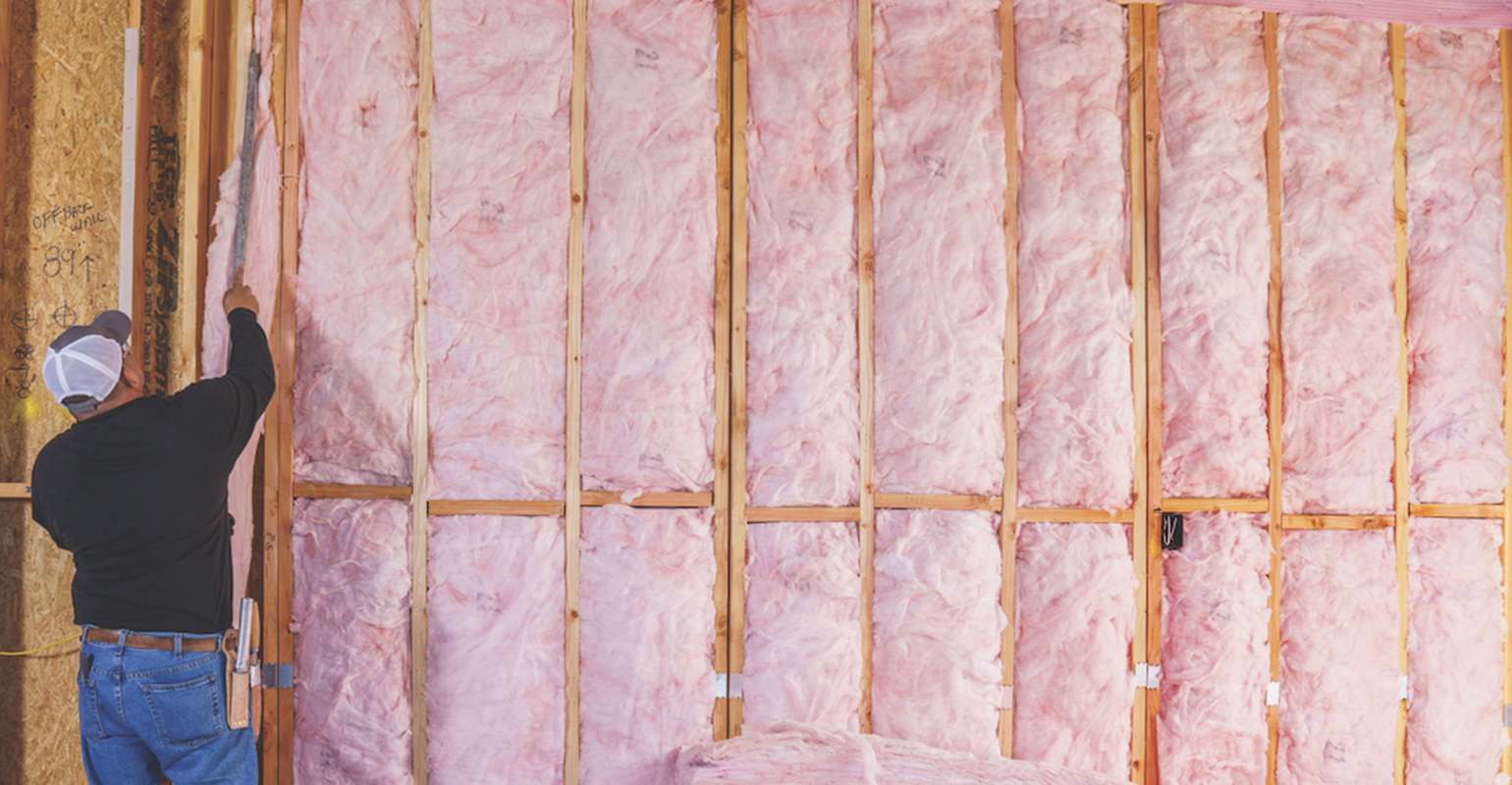Photo of a man installing Fiberglas® insulation