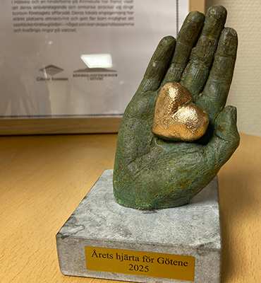 en hand i sten med ett hjärta av guld 