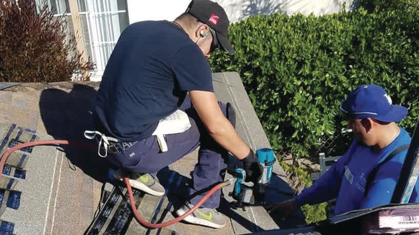 Photo of workers installing shingles on a roof