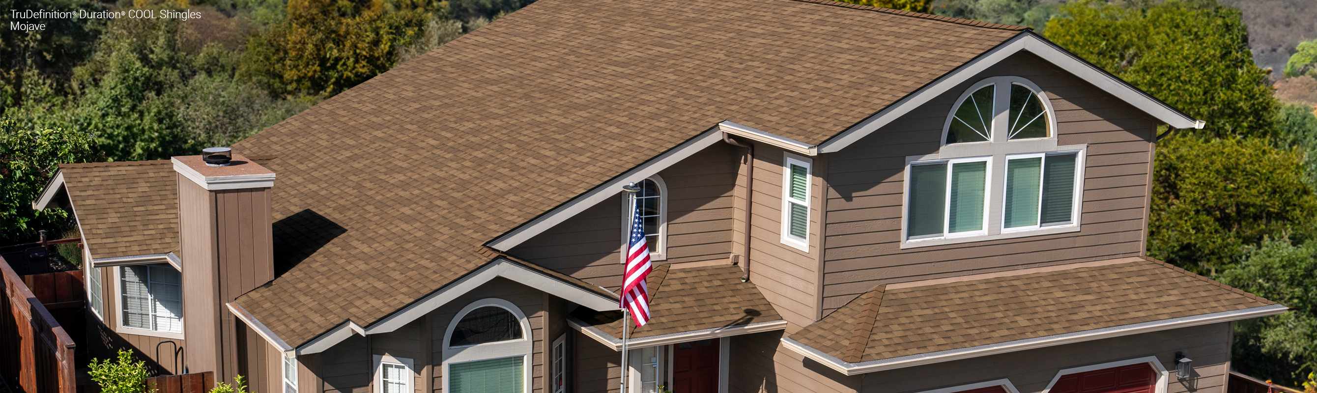 Exterior view of a home with tan siding and Trudefinition Duration COOL Shingles in Mojave color.