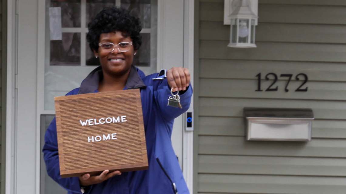 Photo of a representative welcoming home a new family.