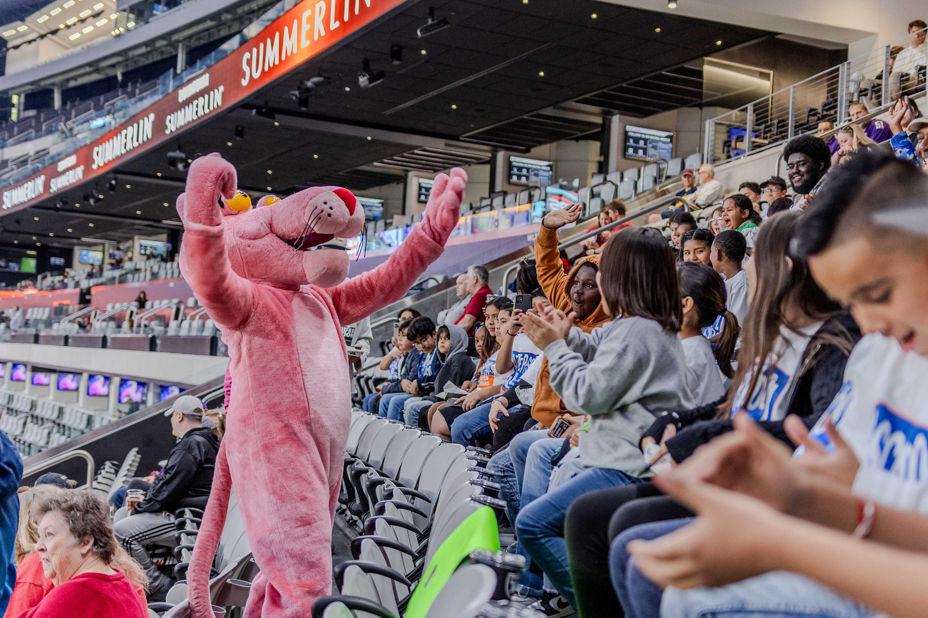La mascota de la Pantera Rosa en las gradas del estadio de fútbol animando a los aficionados a animar.