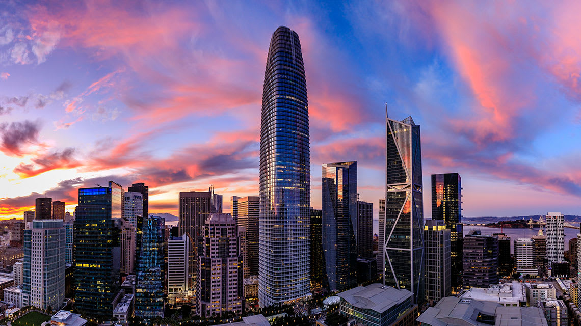 The sun sets behind the SalesForce town in Oakland, California.