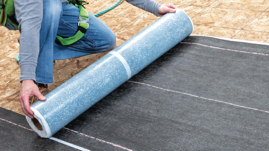 Closeup photo of a contractor on a roof installing WeatherLock® Mat Self-Sealing Waterproofing Barrier
