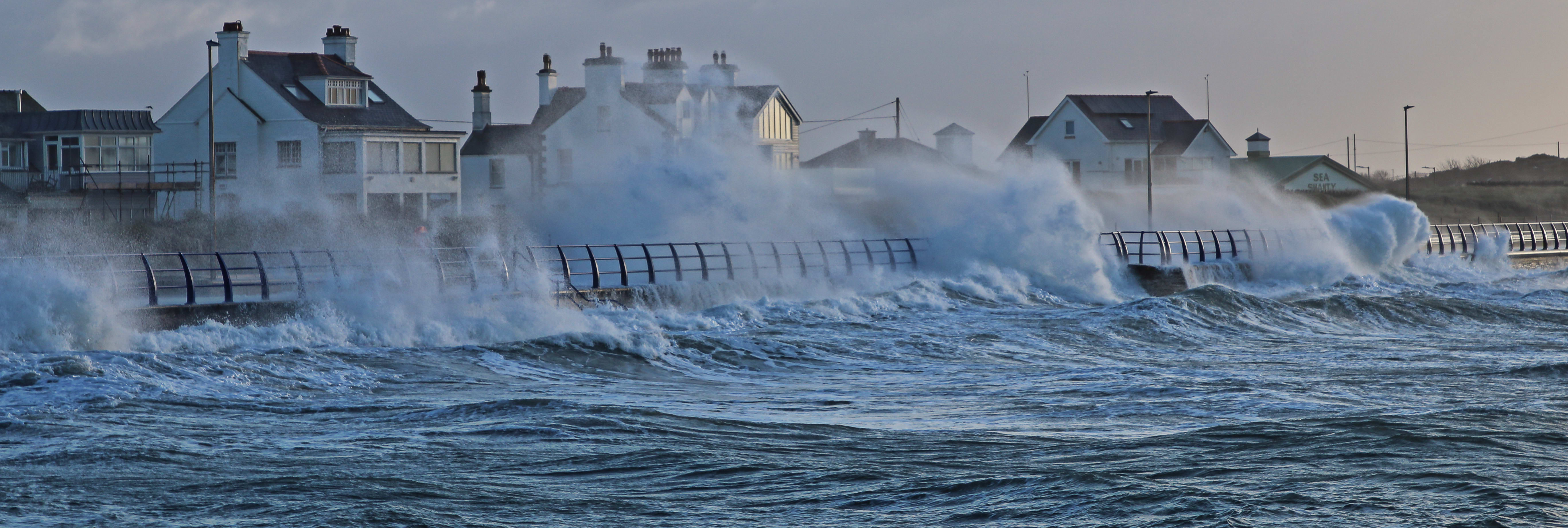 Ocean waves crashing into a coastal apartment building