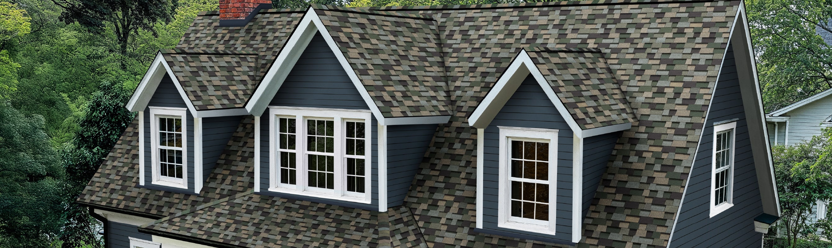 Home with blue siding and dormers with white trim and Owens Corning Trudefintiion Duration Designer shingles in Evergreen Mist.