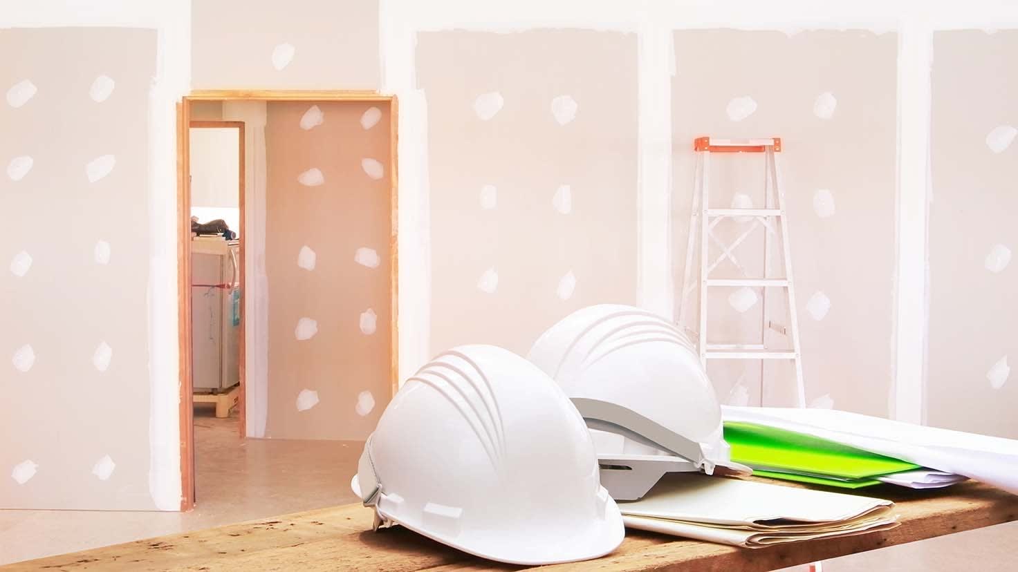 Interior construction site with helmets and documents on a table